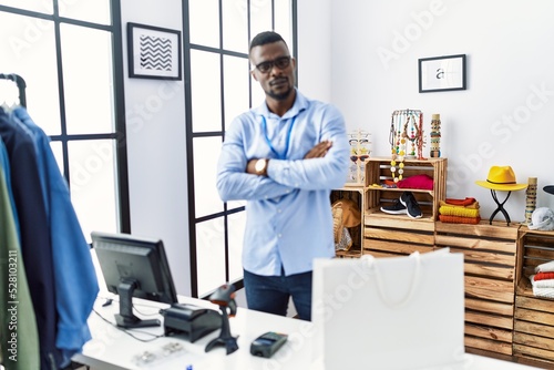 Young african man working as manager at retail boutique skeptic and nervous, disapproving expression on face with crossed arms. negative person.