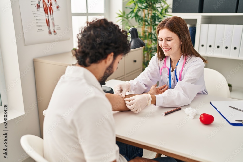 Fototapeta premium Man and woman wearing doctor uniform having blood analysis at clinic