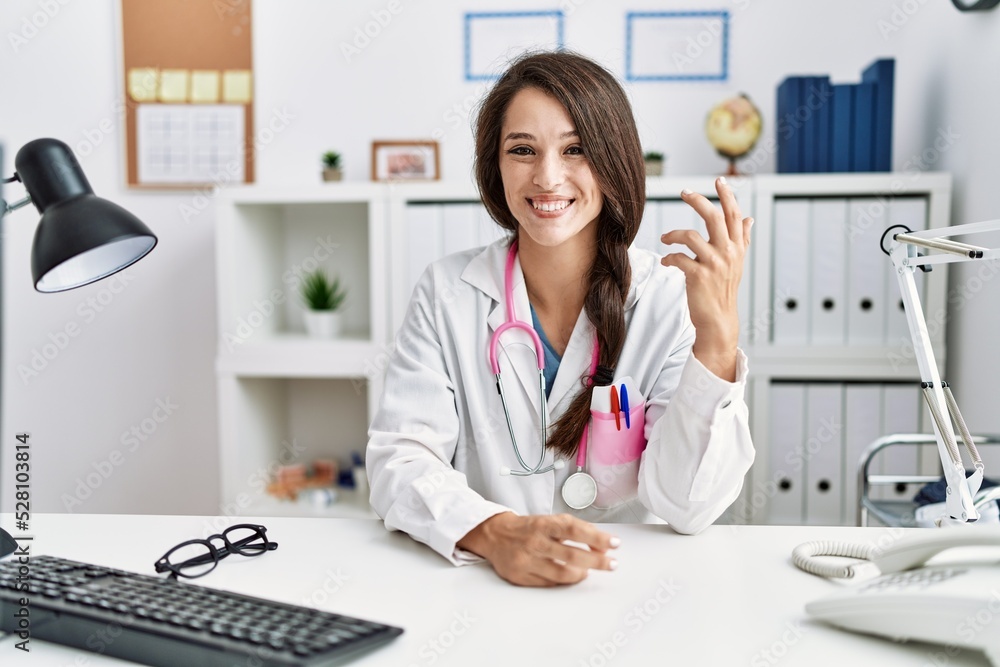 Young hispanic woman wearing doctor uniform working at clinic Young hispanic woman wearing doctor uniform working at clinic