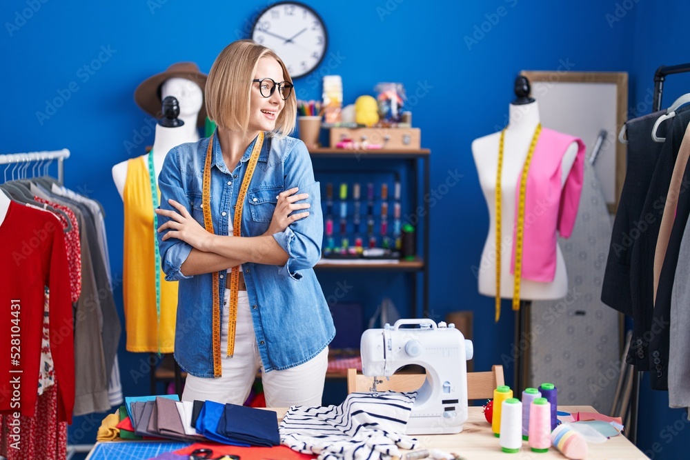 Young blonde woman tailor smiling confident standing with arms crossed gesture at sewing studio