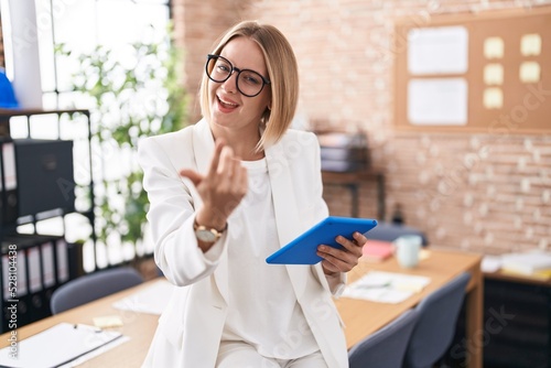 Cuadro en lienzo Young caucasian woman working at the office wearing glasses beckoning come here