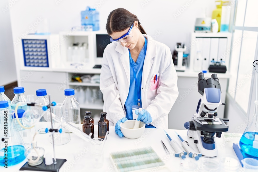Young hispanic woman wearing scientist uniform working at laboratory Young hispanic woman wearing scientist uniform working at laboratory