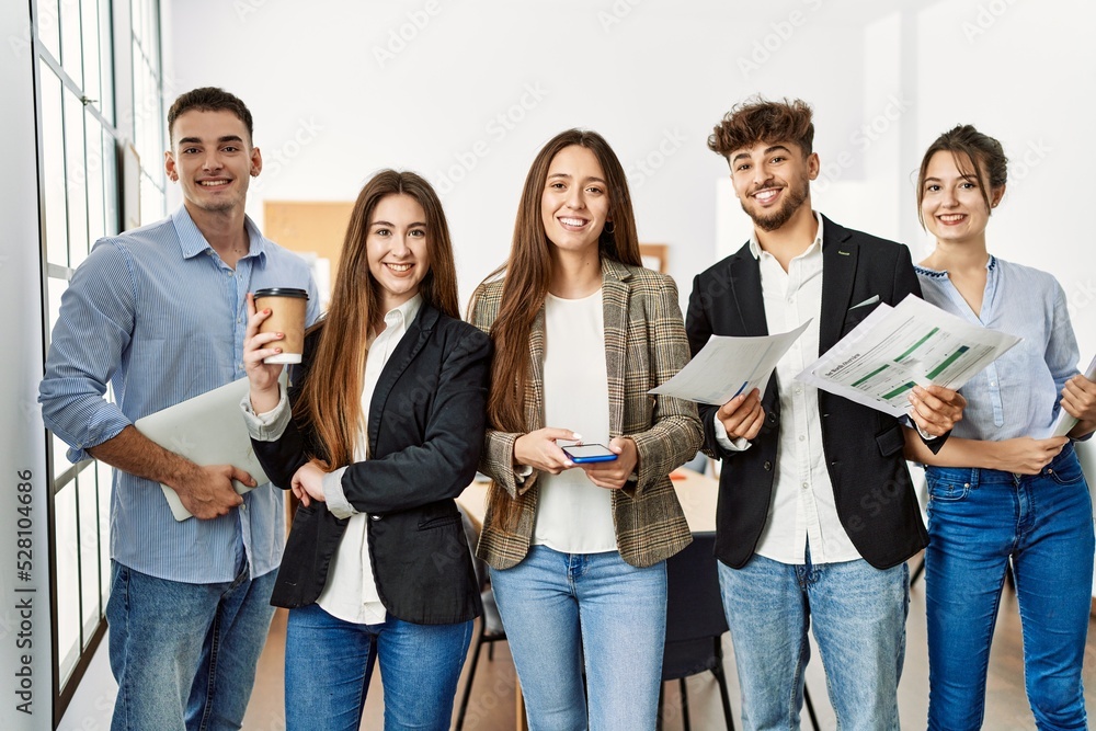 Group of young business workers smiling happy and looking to the camera at the office.