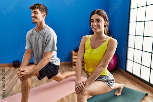 Man and woman couple smiling confident stretching at sport center