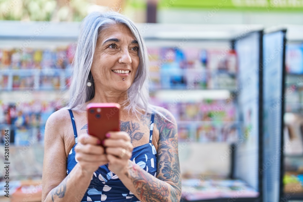 Middle age grey-haired woman smiling confident using smartphone at street Middle age grey-haired woman smiling confident using smartphone at street