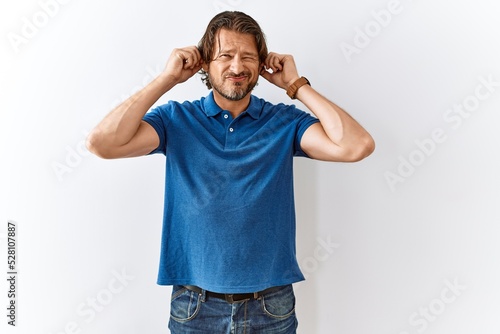 Handsome middle age man standing together over isolated background smiling pulling ears with fingers, funny gesture. audition problem © Krakenimages.com