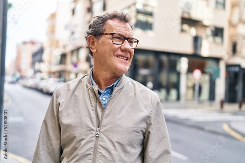 Middle age man smiling confident walking at street © Krakenimages.com