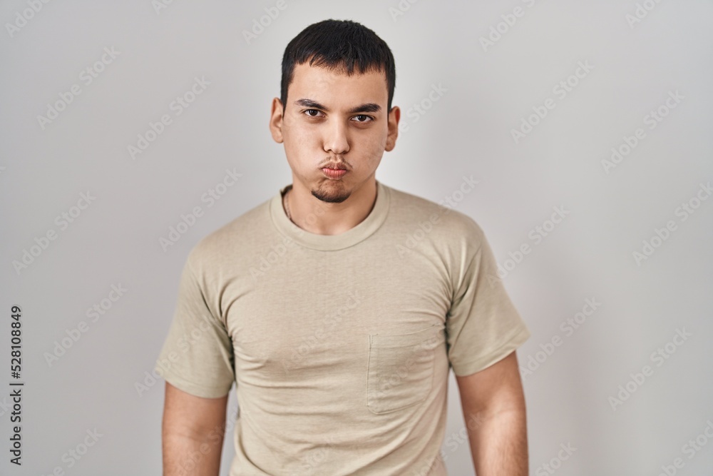 Young arab man wearing casual t shirt puffing cheeks with funny face. mouth inflated with air, crazy expression. Young arab man wearing casual t shirt puffing cheeks with funny face. mouth inflated with air, crazy expression.
