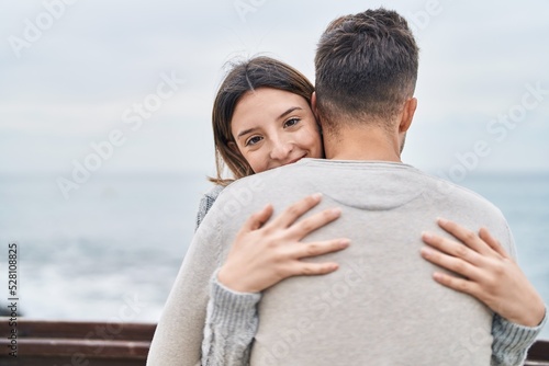 Man and woman couple smiling confident hugging each other at seaside © Krakenimages.com