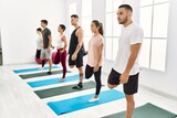 Group of young hispanic people concentrate stretching at sport center.