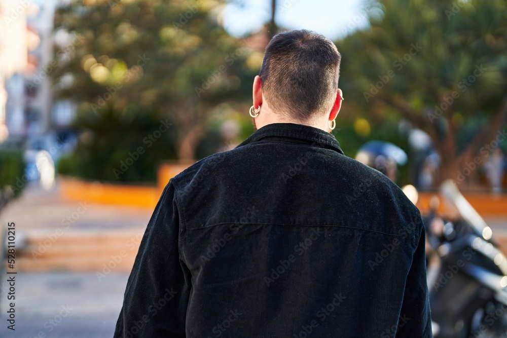 Young hispanic man standing on back view at park Young hispanic man standing on back view at park