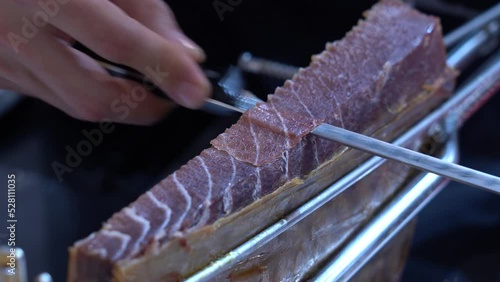 Detalle de las manos de un cocinero cortando almadraba o jamón del mar. photo