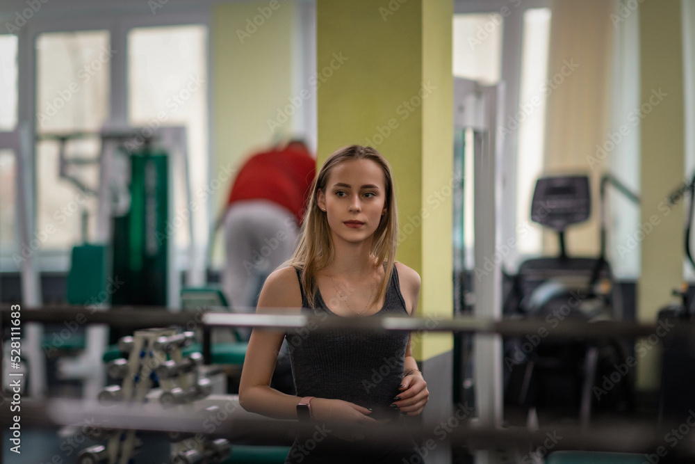 Young beautiful fair-haired girl in a sports uniform in the gym. There is artistic noise. Young beautiful fair-haired girl in a sports uniform in the gym. There is artistic noise.