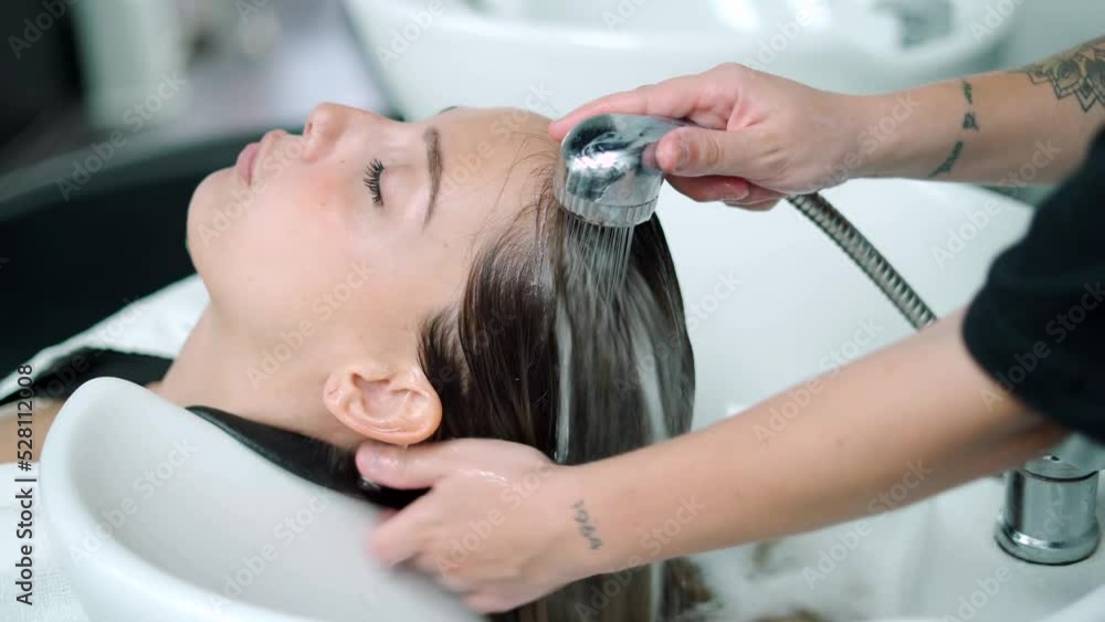 Hairstylist Washing Hair Of Client Over Sink Hairstylist Washing Hair Of Client Over Sink