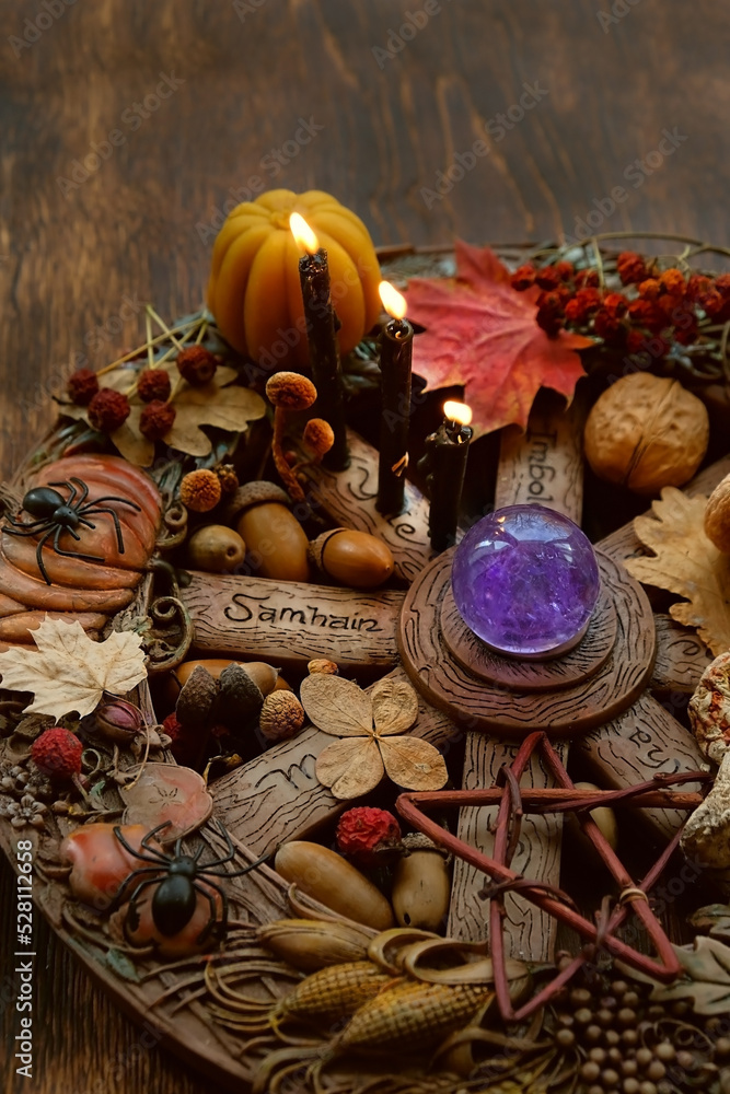wiccan altar on abstract dark wooden background. crystal ball, candles and magic things close up. witch esoteric ritual for samhain sabbat. autumn season