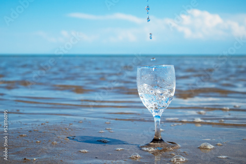Wallpaper Mural water pours into a glass against the background of the sea. clean water in a glass. water splashes Torontodigital.ca