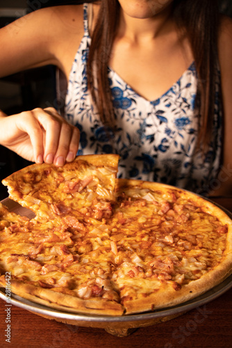 Woman grabbing a hawaiian pizza