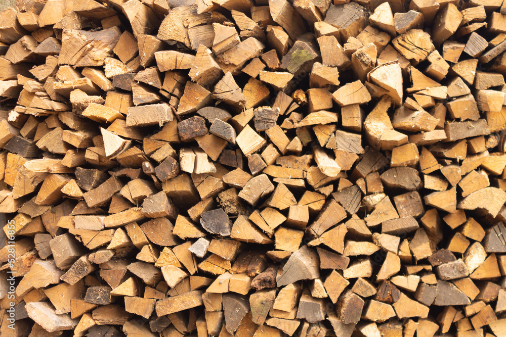 Background of firewood from chopped wood for kindling and heating the house. Woodpile with stacked firewood Background of firewood from chopped wood for kindling and heating the house. Woodpile with stacked firewood