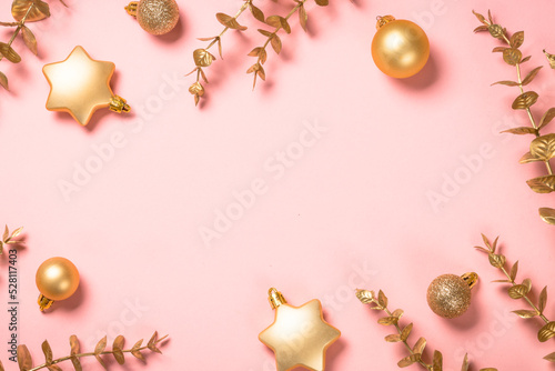 Christmas composition with golden christmas decorations at pink. Christmas greeting card. Flat lay image with copy space.