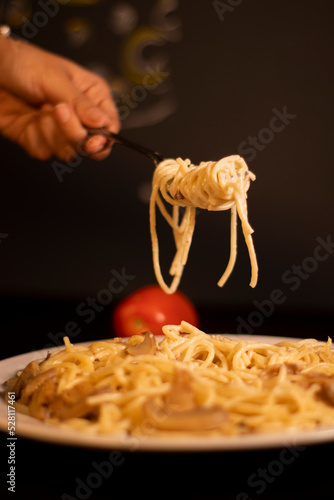 Fork holding spaghetti with tomato sauce