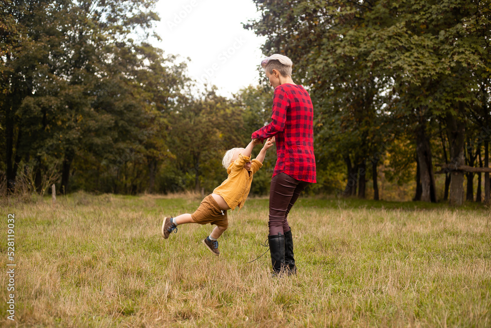 Mother playing with her little son in autumn or summer forest Mother playing with her little son in autumn or summer forest