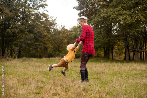 Mother playing with her little son in autumn or summer forest