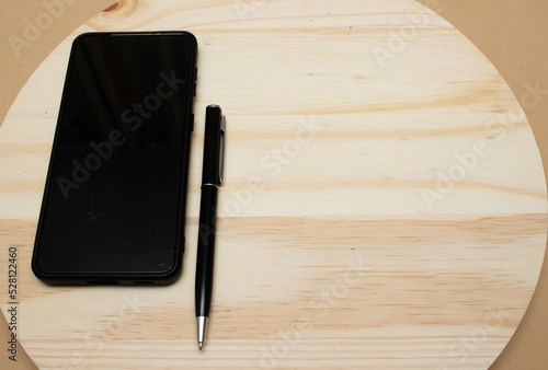 smartphone and pen near notepad on desk- office