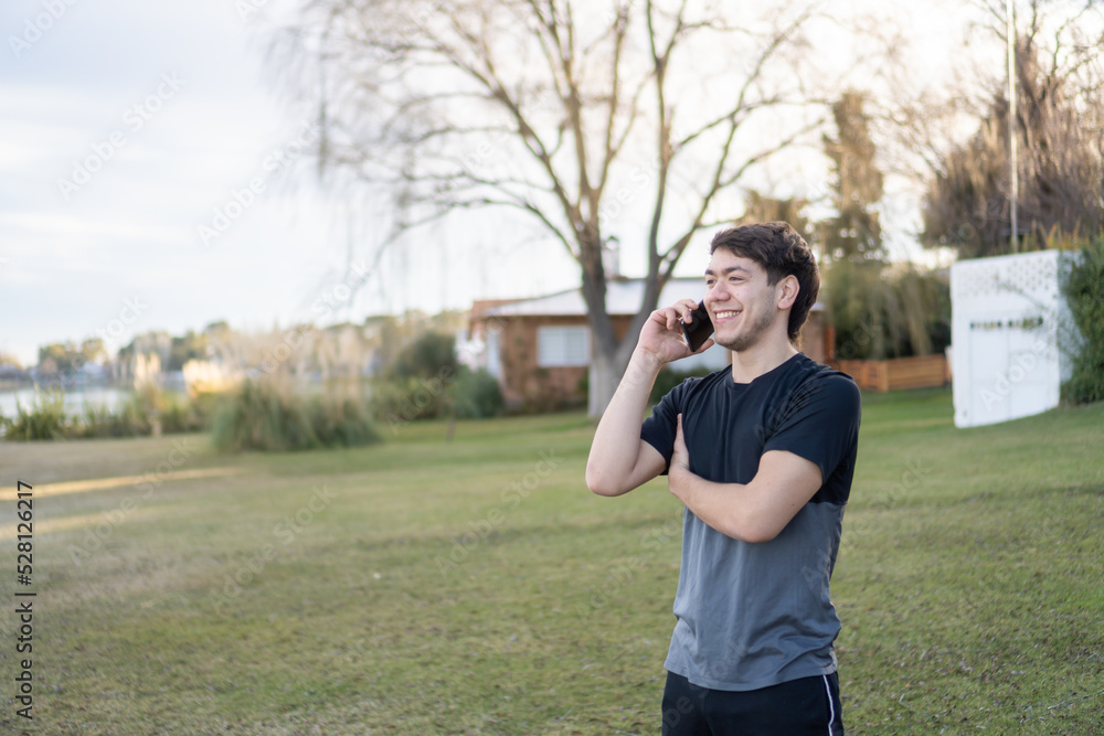 young man smiling while having a phone call young man smiling while having a phone call