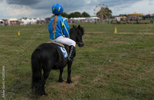 Young person dressed as a jockey on a pony