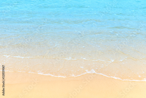 Soft blue ocean wave on clean sandy at the beach