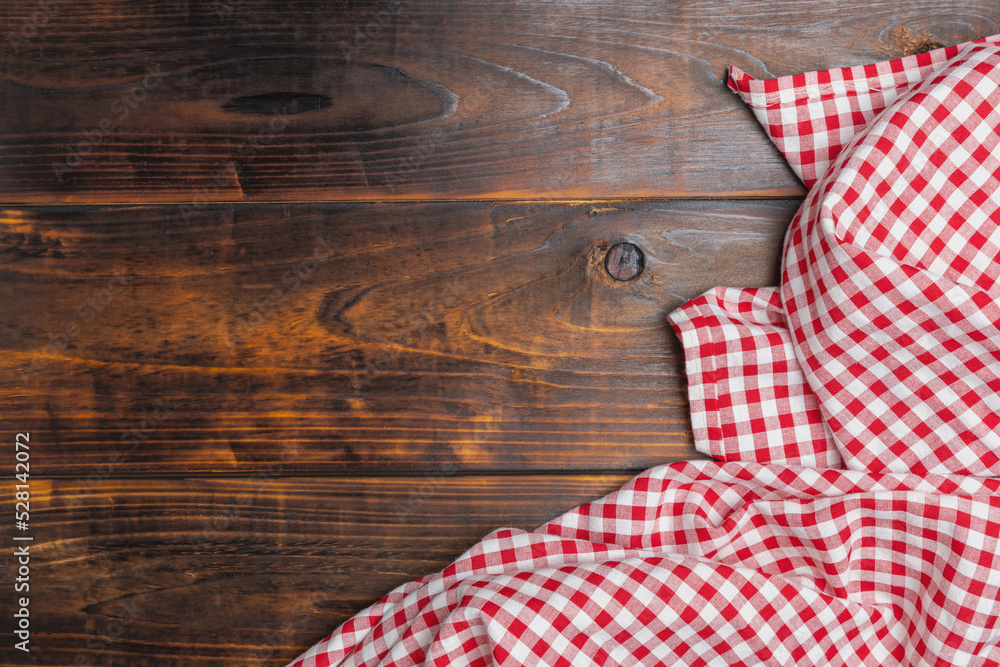 Background with copy space for design menu of food for restaurant. Tablecloth red and white checkered squared on old wooden, top view. Fabric texture background. Texture of cotton fabric. Background with copy space for design menu of food for restaurant. Tablecloth red and white checkered squared on old wooden, top view. Fabric texture background. Texture of cotton fabric.