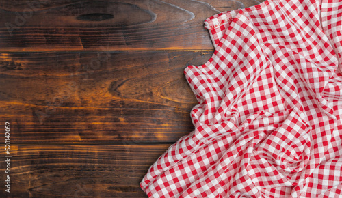 Fabric texture background. Checkered red and white on an old wooden background with copy space, top view. The texture of the cotton fabric. With copy space for design menu of food for the restaurant.