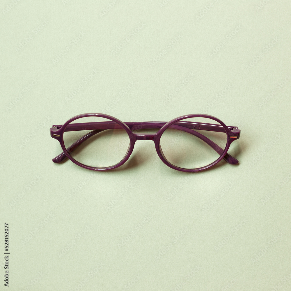 Purple eye glasses isolated on green background. copy space