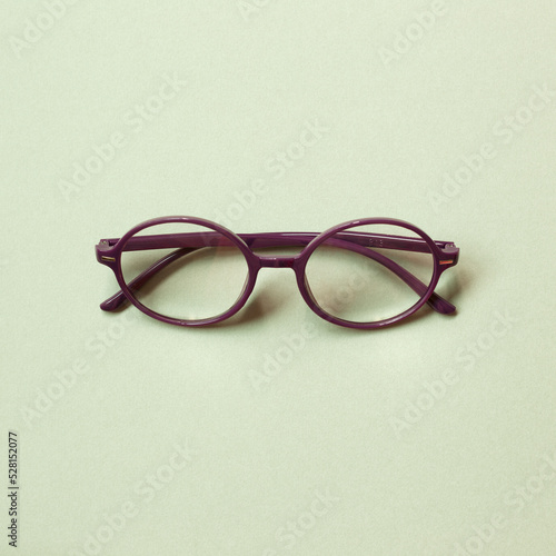 Obraz na płótnie Purple eye glasses isolated on green background. copy space w salonie