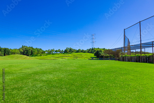青空のゴルフ場・島になった浮きグリーンへの池越えコースの眺め（千葉県木更津市）