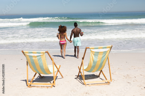 Mixed race couple holding hands on the beach
