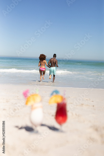 Mixed race couple running to the sea