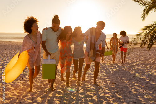 Mixed race friends group walking on beach