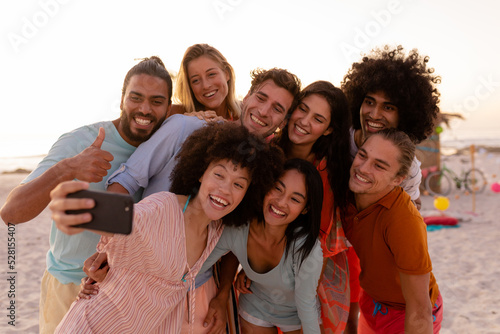 Multi-ethnic group of male and female taking a selfie on the beach