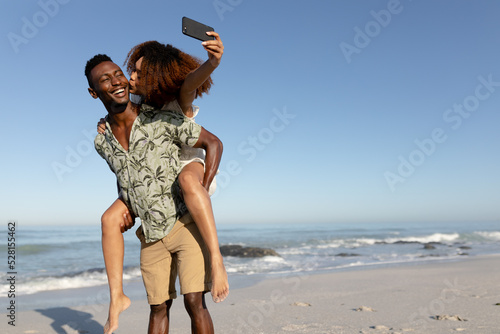 Happy couple taking a selfie on the beach