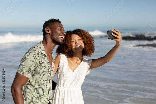 Happy couple taking a selfie on the beach