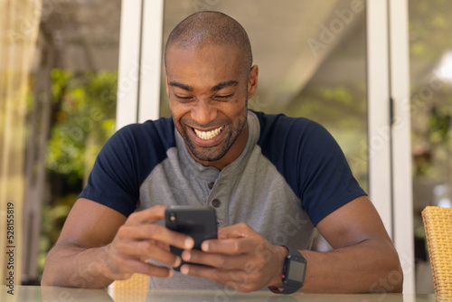 Young man smiling while using his mobile phone