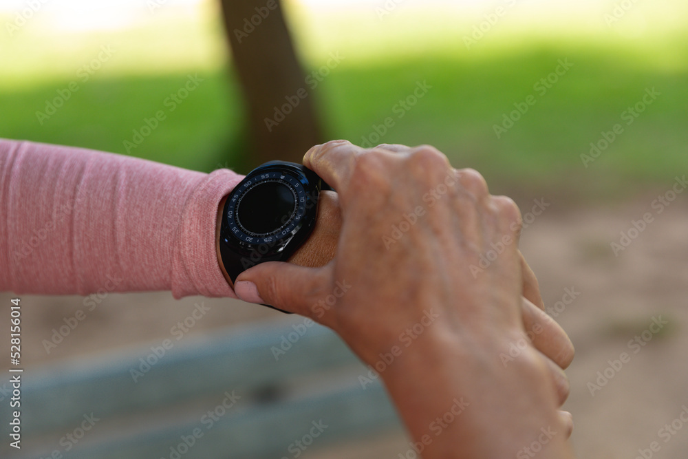 Female jogger using smart watch in the park