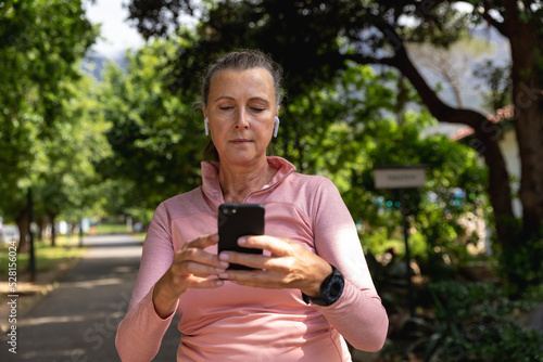 Female jogger using mobile phone in the park