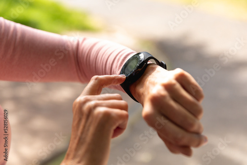 Female jogger using smart watch in the park