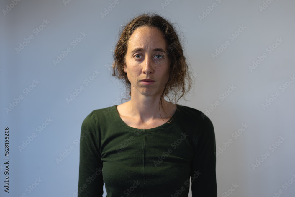 Caucasian woman standing in an empty white room isolating and social distancing in quarantine lockdo Caucasian woman standing in an empty white room isolating and social distancing in quarantine lockdo