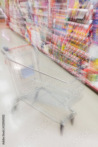 Defocused image of empty shopping cart in supermarket 