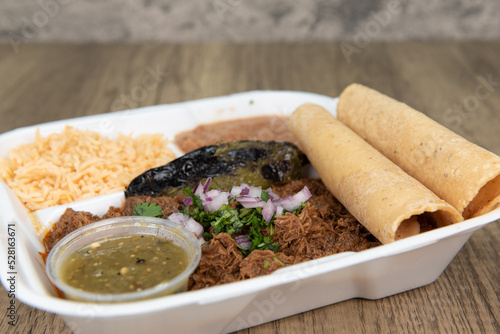 Generous serving of slow cooked birria meat, served with corn tortillas, rice, beans, and salsa for a tempting meal