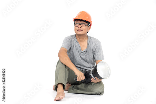 A middle-aged Korean engineer in a private suit and orange hat sits and relaxes.Full length studio shot isolated on white. 