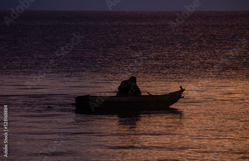 Persona transportándose por bote en el amanecer